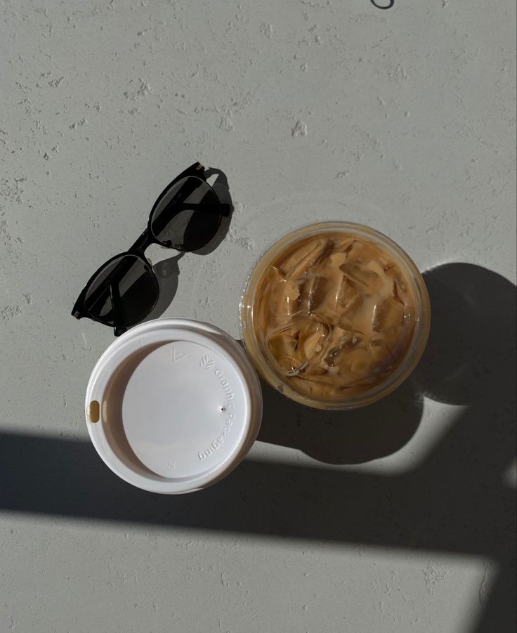 an overhead view of a cup of coffee and sunglasses