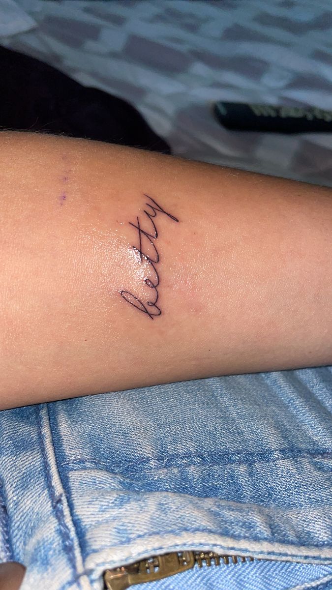 a woman's arm with the word faith written in cursive writing on it