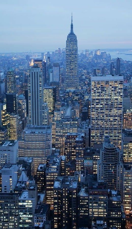 an aerial view of new york city at night with the empire building in the background