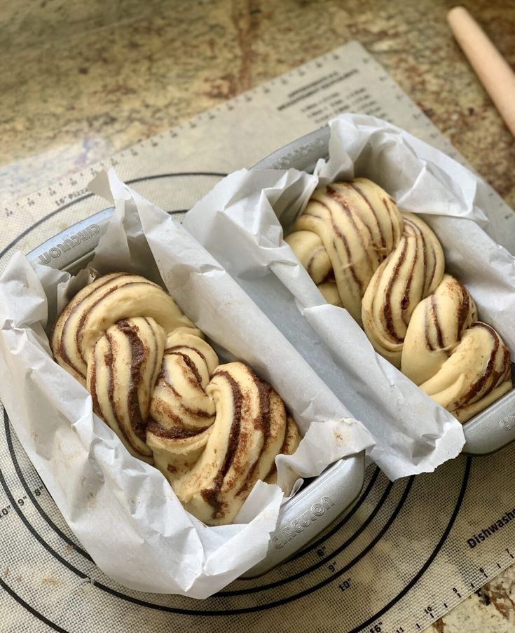 two pastries sitting on top of a pan covered in wax paper