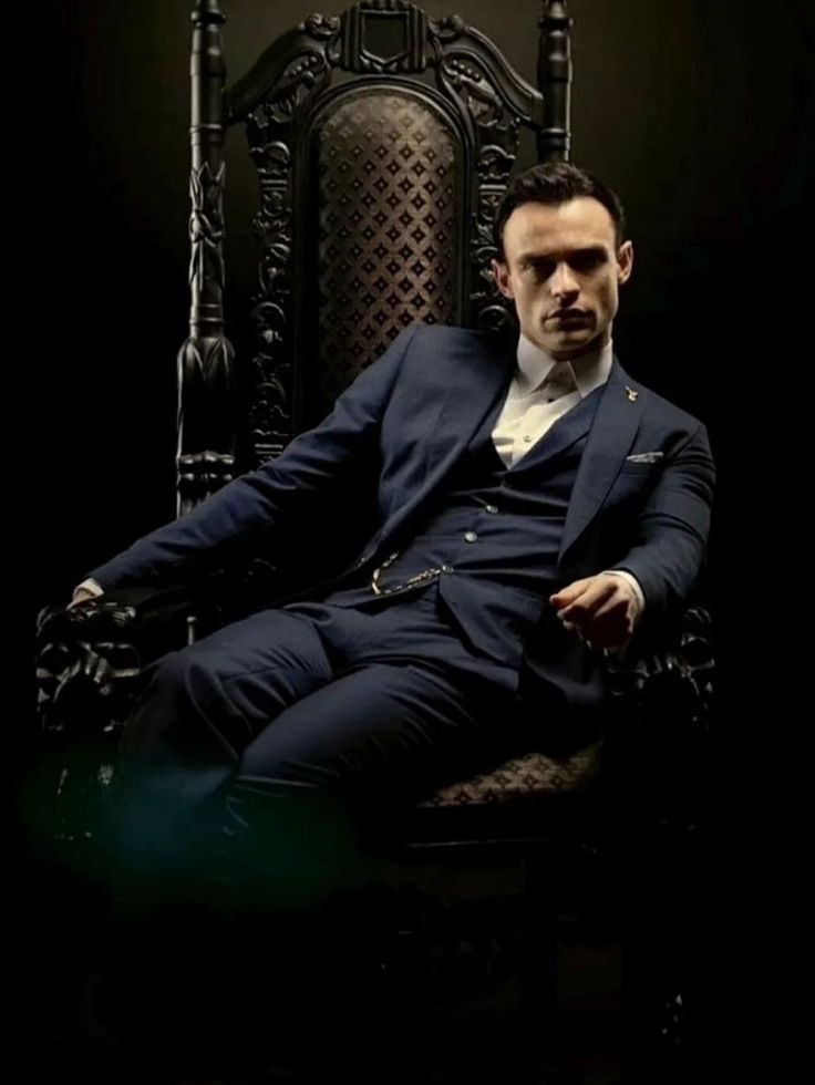 a man in a suit sitting on a chair