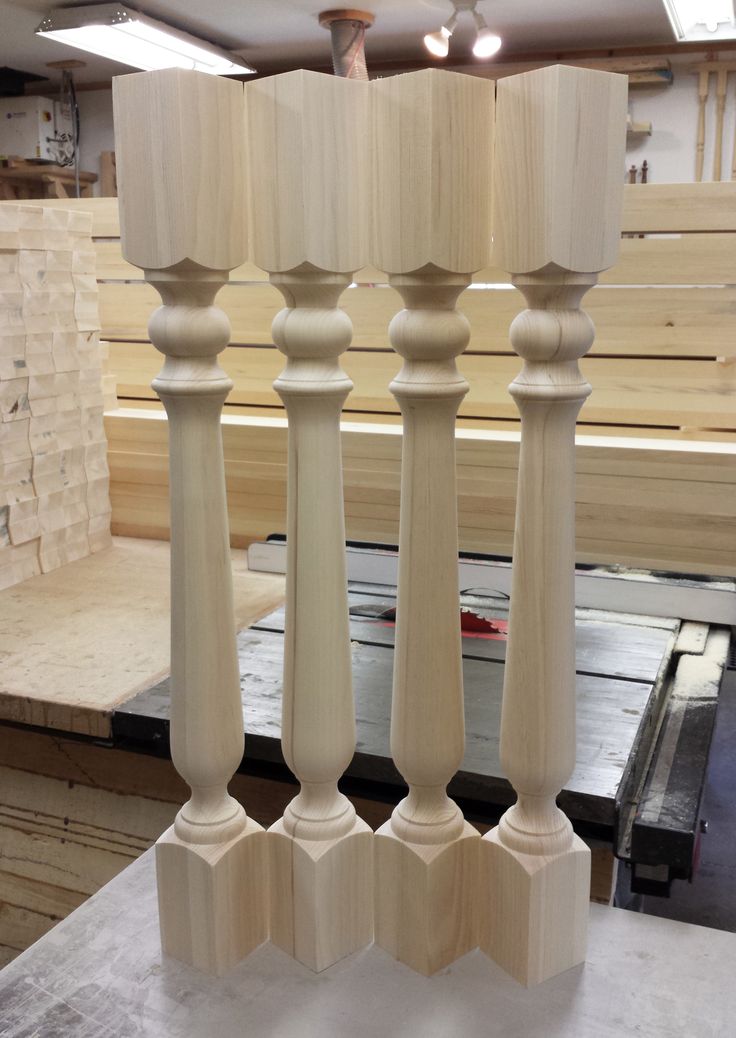 three white candlesticks on top of a table in a room filled with wood planks