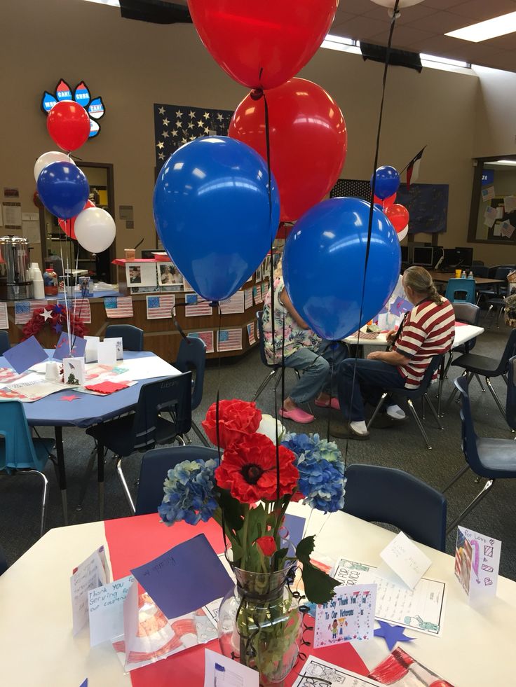 red, white and blue balloons are on display in a classroom