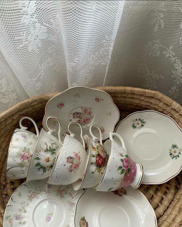 a wicker basket filled with tea cups and saucers on top of each other