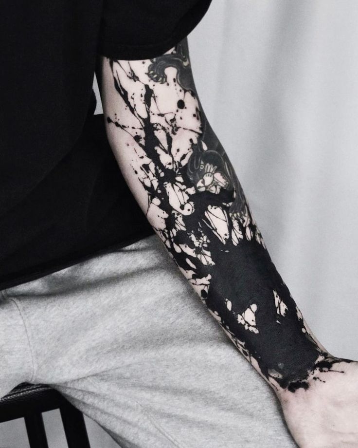 a man's arm with black ink splattered on it