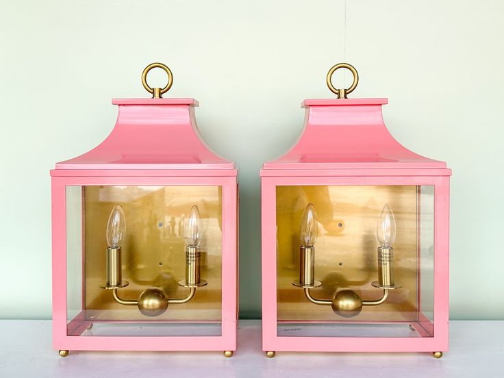 two pink and gold lanterns sitting side by side