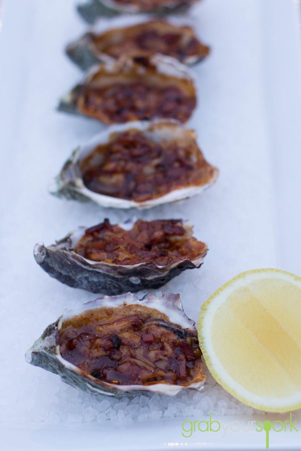 several oysters on ice with a lemon wedge