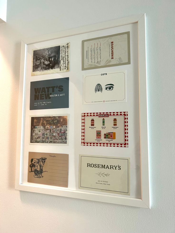 a white frame with many different business cards mounted to it's side on the wall