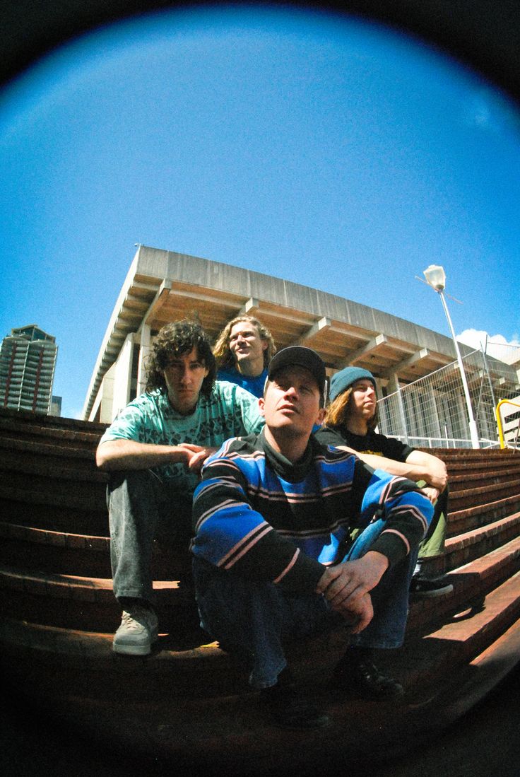 three young men are sitting on the bleachers