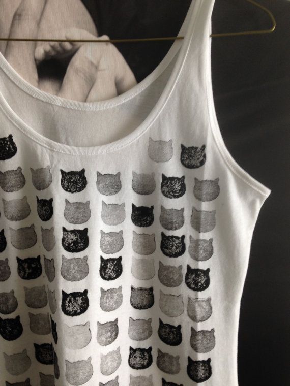 a white shirt with black cats on the front and grey cat print on the back