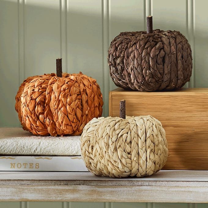 three woven pumpkins sitting on top of books