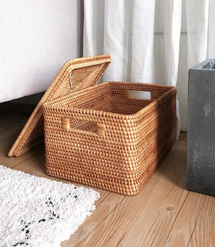 two wicker baskets sitting on the floor next to each other in front of a window