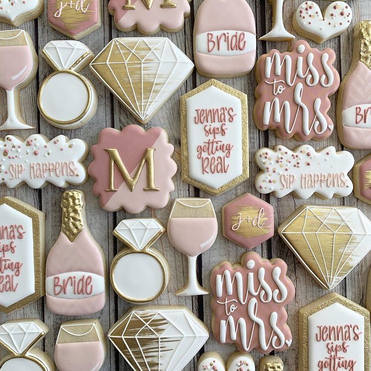 decorated cookies are arranged on a table with pink and white icing, gold trimmings, and diamond accents