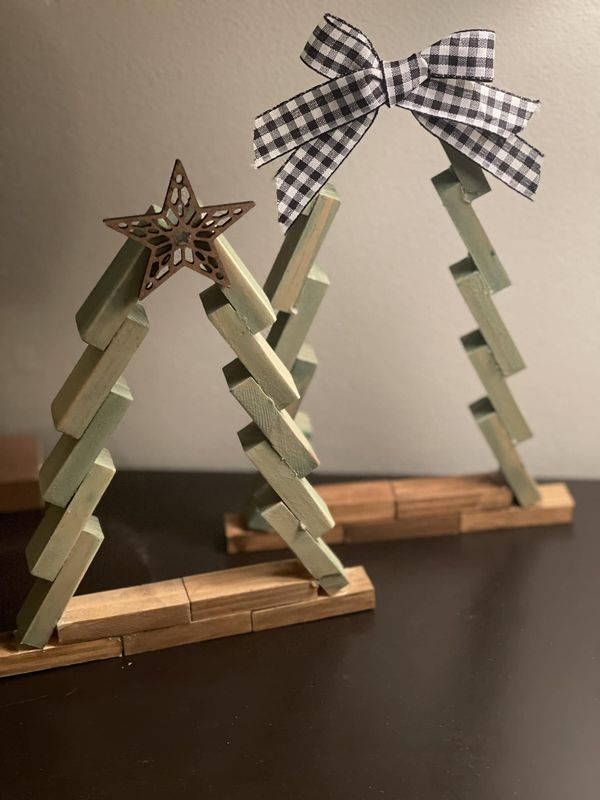 two wooden christmas trees with bows on them