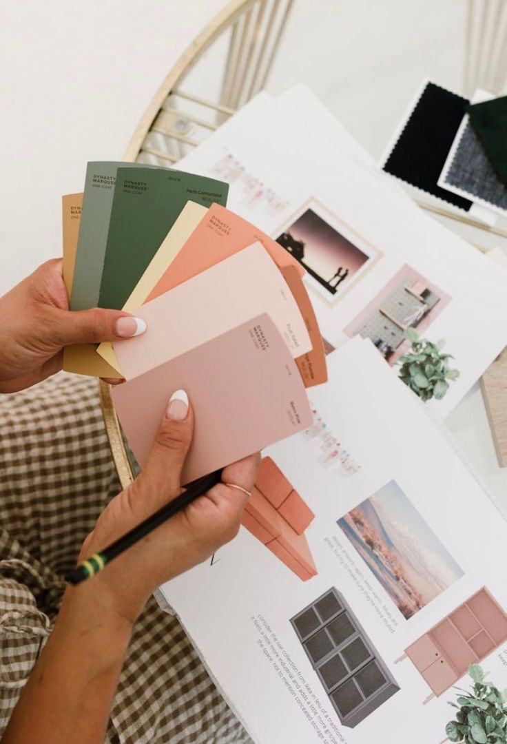 a person is holding several different colors of paper