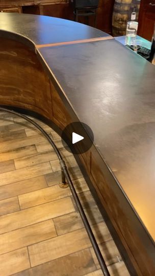 a curved metal counter top on a wooden floor