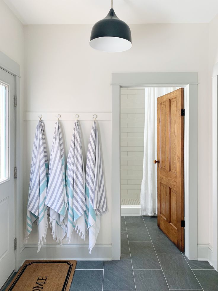 three towels hanging on the wall in a bathroom with blue and white striped towel racks