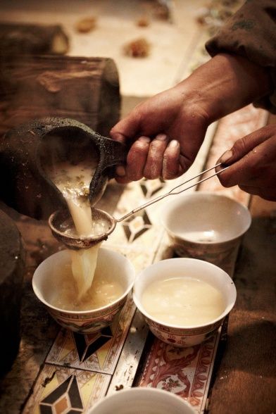 a person pouring milk into small bowls