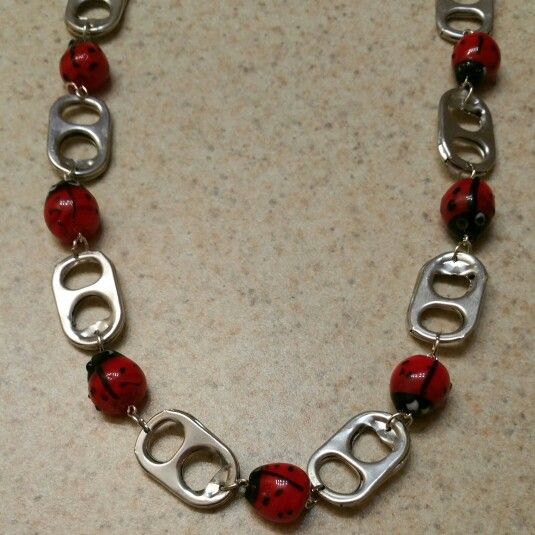 a red and black beaded bracelet with silver clasps on a counter top or floor