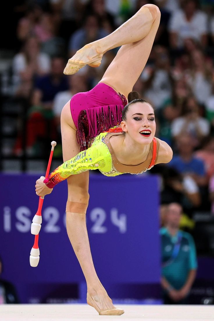 a woman doing a handstand on the balance beam