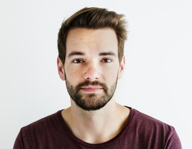 a man with a goatee and beard looks at the camera while wearing a maroon shirt