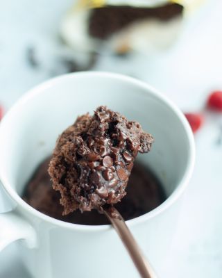 a spoon full of chocolate pudding in a white mug