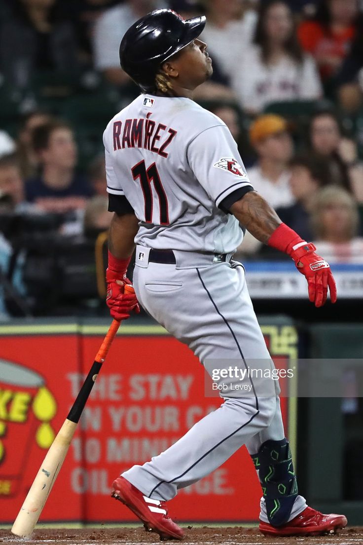 a baseball player holding a bat on top of a field in front of a crowd