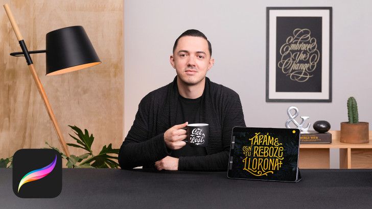 a man sitting at a table with a laptop and coffee cup in front of him