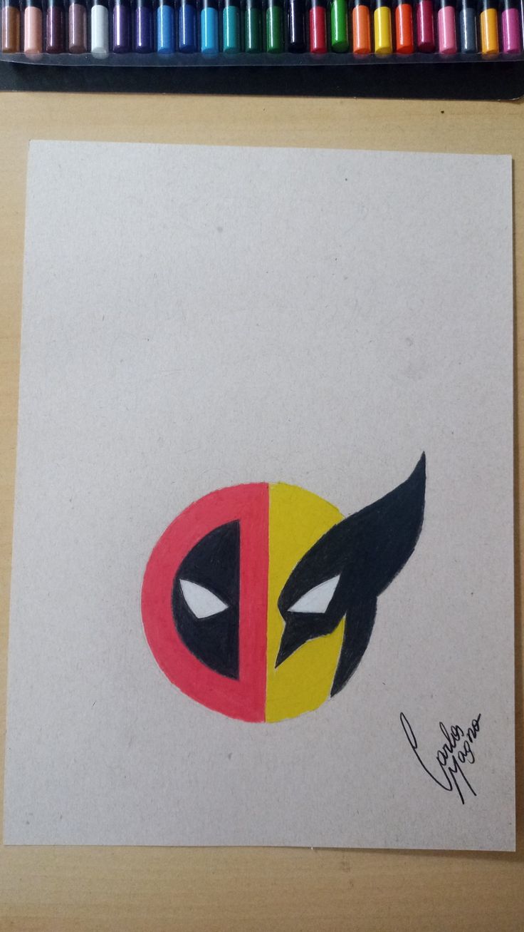 a drawing of a deadpool mask with colored crayons on the table next to it