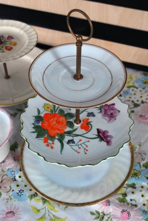 three plates with flowers on them sitting on a floral table cloth next to each other