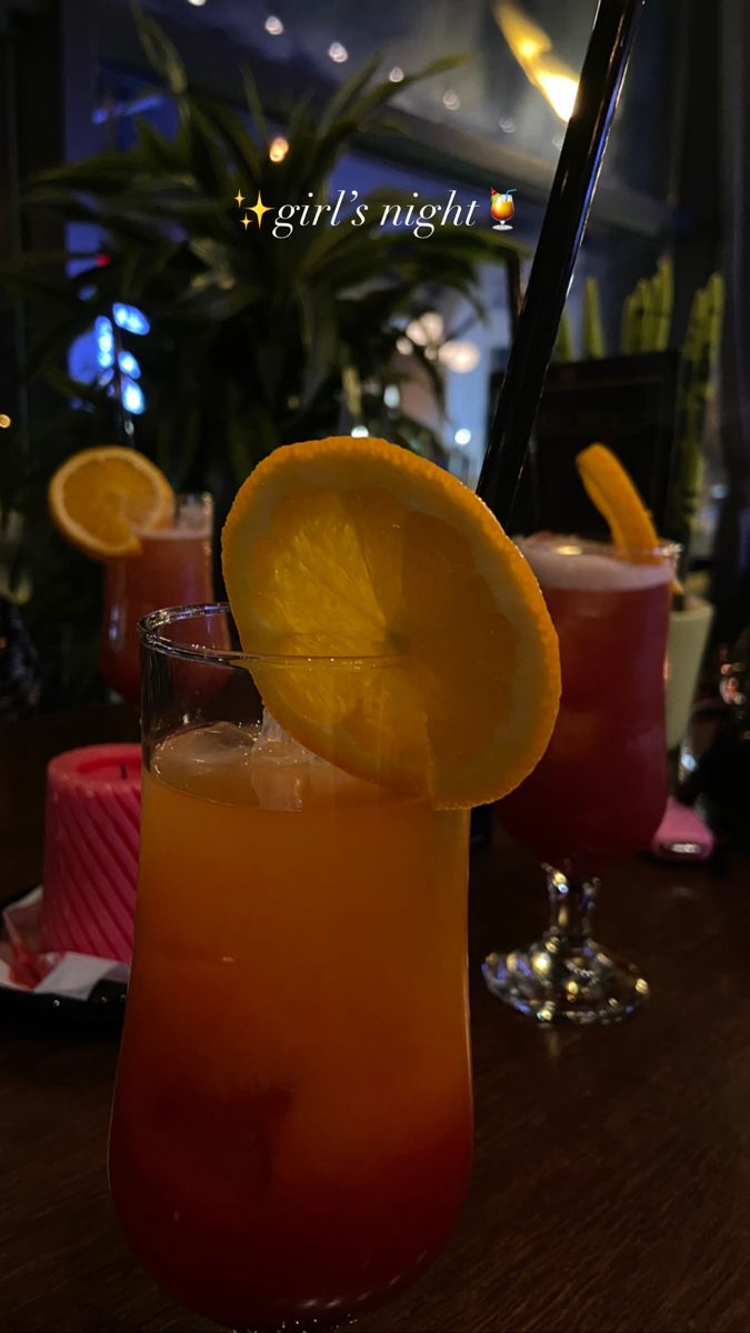 two glasses filled with drinks sitting on top of a table