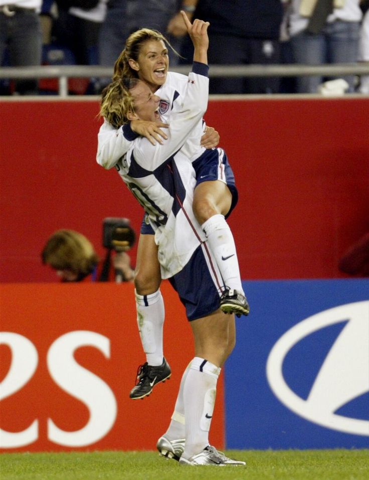 two soccer players are hugging each other on the field