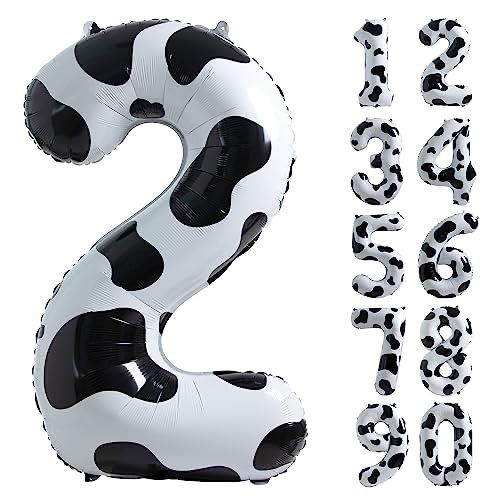 the number two is made out of black and white cow print balloons, which are shaped like soccer balls