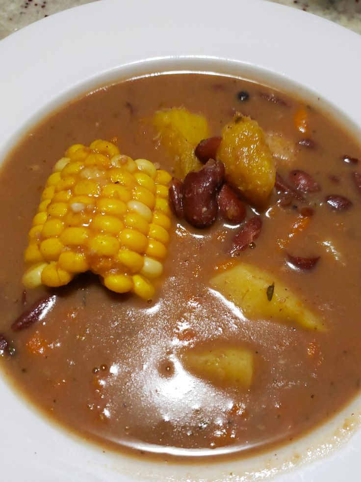 a white plate topped with soup and corn