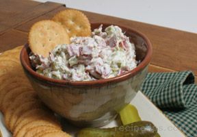 a bowl filled with food next to crackers and pickles