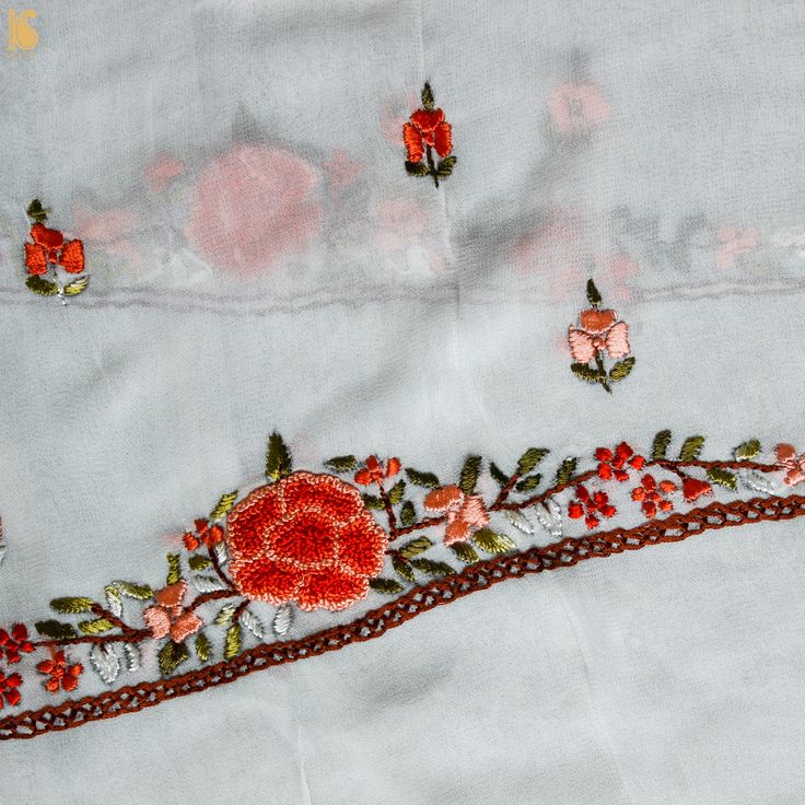 an embroidered cloth with flowers and leaves on it