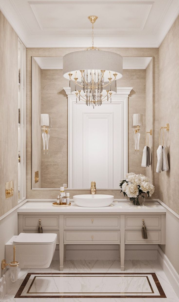 an elegant bathroom with chandelier, toilet and sink