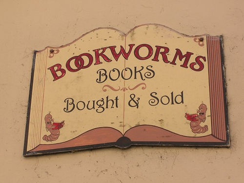 a sign on the side of a building advertising books bought and sold by bookworms