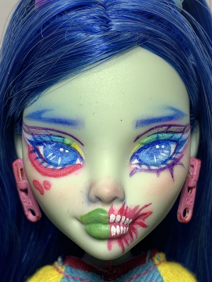 a close up of a doll with blue hair and makeup on it's face