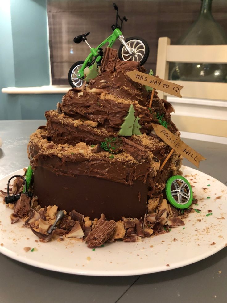 a cake that is sitting on top of a white plate with dirt and dirt bike decorations