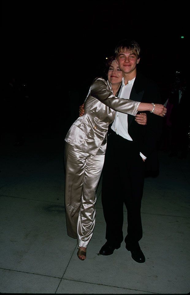 a man and woman dressed in evening wear dance together at an event with their arms around each other