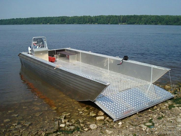 a boat sitting on top of a body of water next to a shore covered in rocks