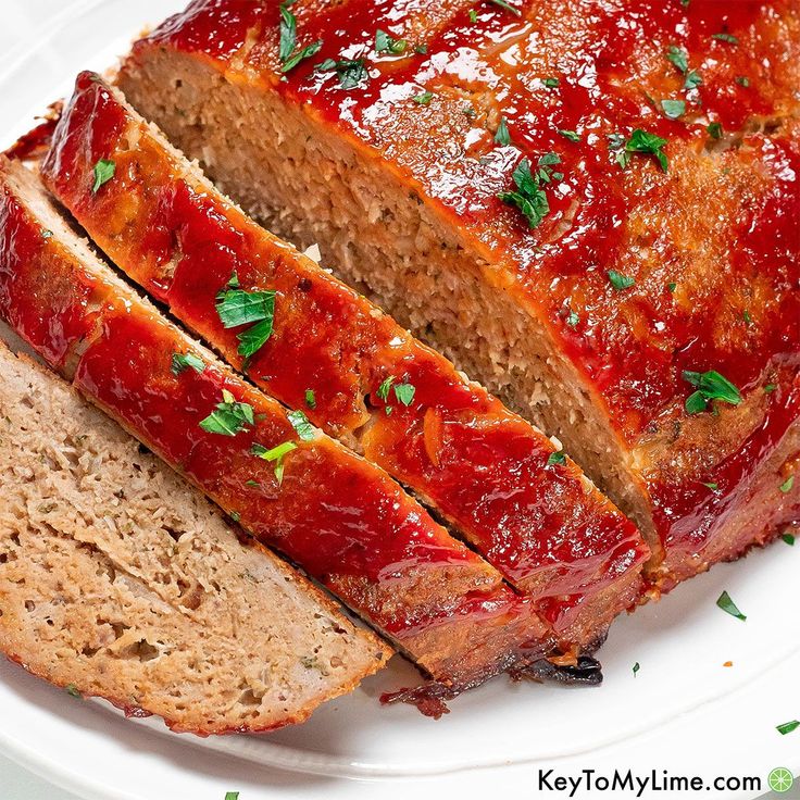 sliced meatloaf on a white plate with parsley