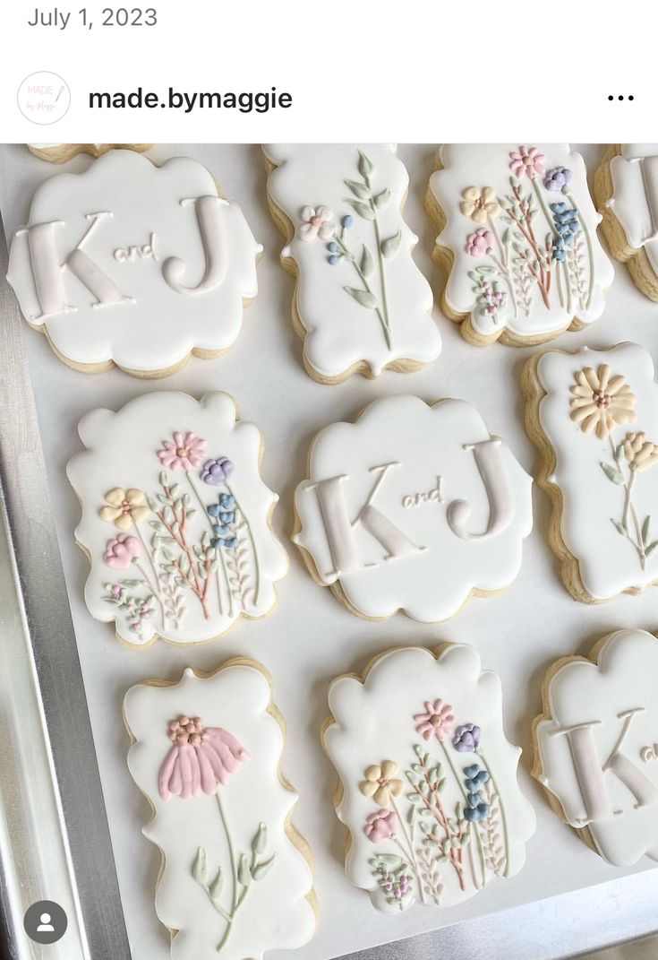 decorated cookies with the letters k and j are displayed on a cookie sheet that says made by mymagicle