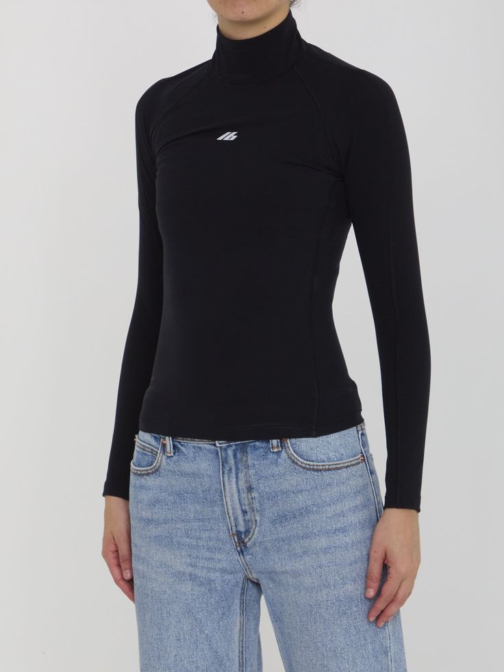 Black long-sleeved high-collar top in matte spandex featuring a printed Activewear logo on the front. Visible topstitching. Tight fit. Size nationality: US Product number: 7774508 Product code: 7970414E2B91081 Composition: 58% polyamide, 42% elastane Casual Long Sleeve Mock Neck Top, Sleek Turtleneck Tops With Thumbholes, High Neck Tops With Thumbholes, High Neck Tops With Thumbholes In Elastane, Sleek Black Long Sleeve Turtleneck, Stretch Elastane Turtleneck Long Sleeve Top, Stretch Turtleneck Long Sleeve Top, Functional Long Sleeve Elastane Tops, Stretch Turtleneck Long Sleeve Top In Elastane