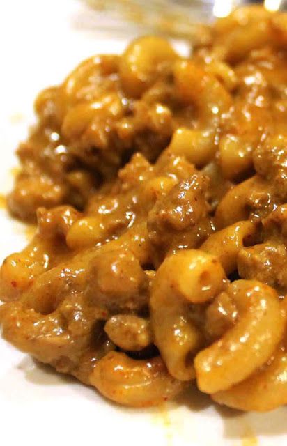 a close up of some food on a white plate with a fork in the background