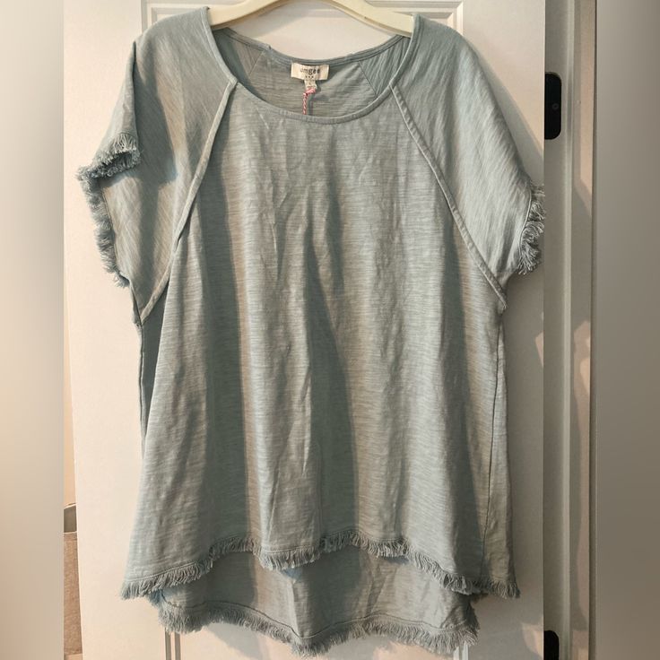 This Top Is A Beautiful Light Greenish Gray Color. The Fringe On The Sleeves And Bottom Is So Cute. It Doesn’t Fit Me And Has Never Been Worn. Light Wash Tops With Frayed Hem For Day Out, Casual Summer Blouse With Frayed Hem, Light Wash Short Sleeve Top With Frayed Hem, Summer Short Sleeve Tops With Frayed Hem, Casual Cotton Blouse With Frayed Hem, Summer Light Wash Tops With Frayed Hem, Light Wash Tops With Frayed Hem For Summer, Summer Crew Neck Top With Frayed Hem, Umgee Tops