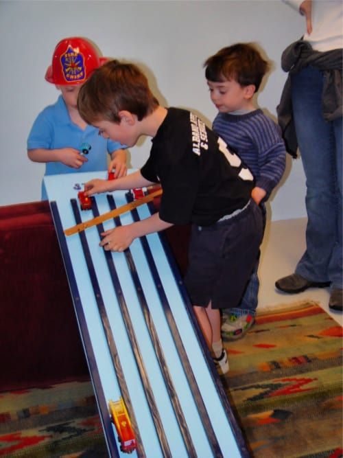 two young boys playing with toy train tracks