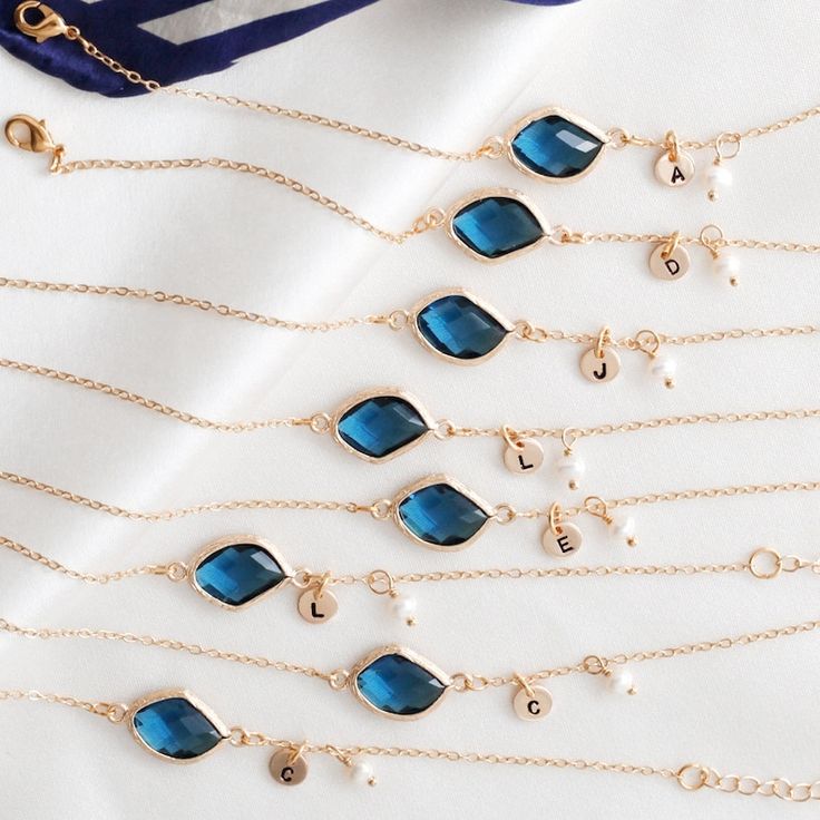 several different types of necklaces are displayed on a white surface with gold chains and blue stones