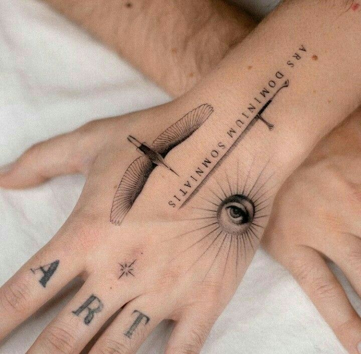 two hands that have tattoos on them, one with an eye and the other with a cross